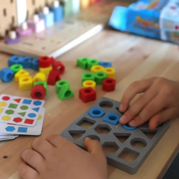 Дете се забавлява с WOOPIE логическа игра за сортиране на форми.