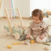Дете играе с дървена проходилка за бутане